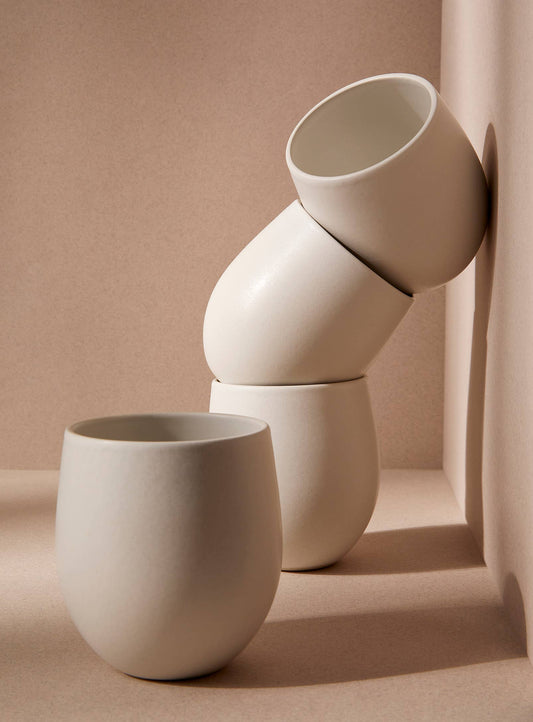 A stack of Gharyan stoneware mug on a neutral background, showcasing sustainable design and minimalist style.